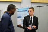Patrick Messimer mesmerizes Delon Roberts with his presentation on a high-functioning robotic hand.
