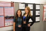 Ariana Macias and Danica Albright pose in front of their poster at the Showcase.